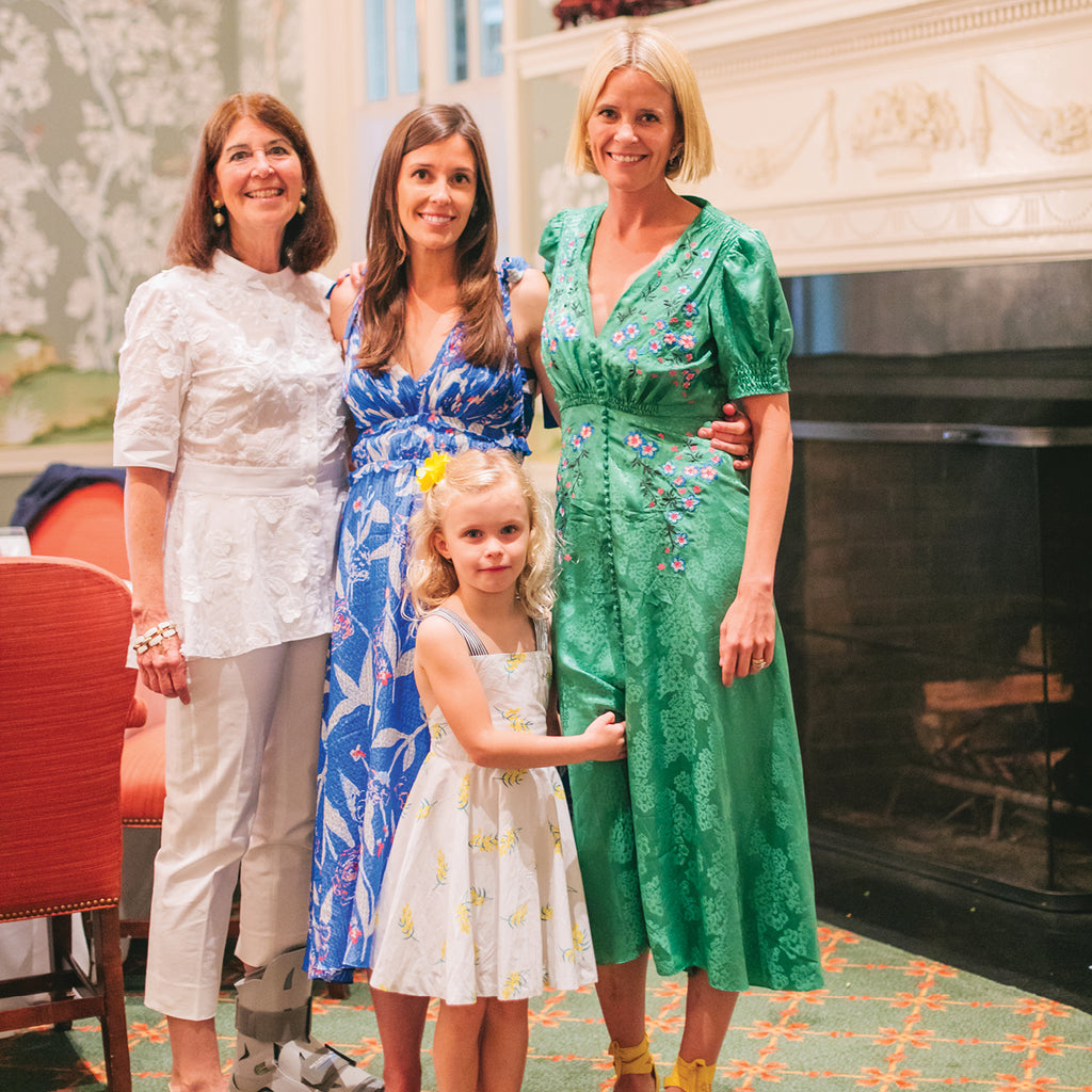 Four people in classic, high-end attire: women in embroidered blouses and sundresses, young girl in a white dress. Effortless, fun fashion from Tuckernuck.