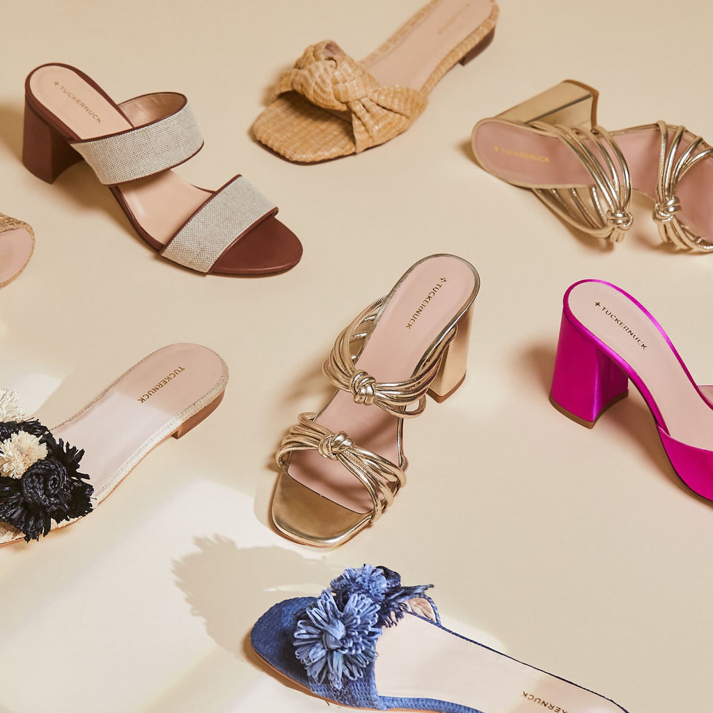 Flat-lay of classic, high-end women's slip-on sandals and mules, featuring effortless designs with block heels and flat soles in fun colors and textures.