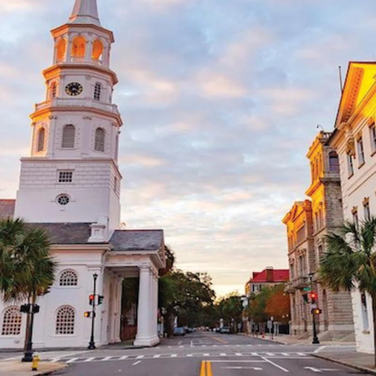Historic white church with a classic steeple, palm trees, and period-style buildings at a quiet intersection, embodying an effortless and high-end charm.