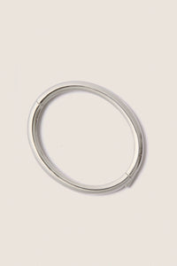 Classic and effortless, the Silver Gia Bangle features a smooth, polished surface with a hinge push closure, embodying a fun, high-end style ideal for any occasion.
