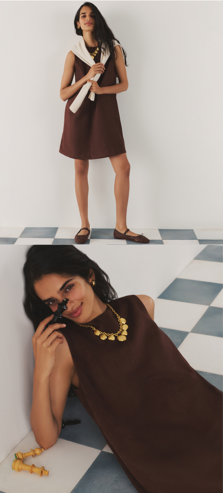 Woman in a brown shift dress and a gold necklace with a cream sweater over her shoulders.