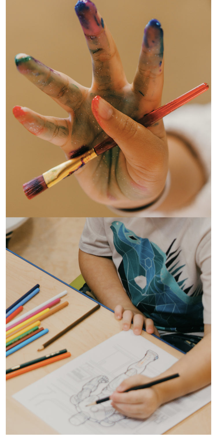 Child's hand covered in paint holding a paintbrush. Child coloring in an illustration of a superhero.