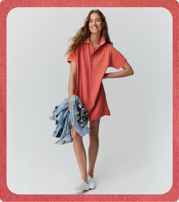 Woman in a red polo dress holding a jean jacket covered in plaid buttons.
