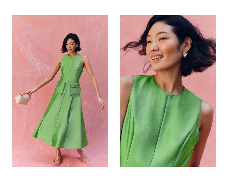 Woman in a green sleeveless midi dress standing in front of a pink background.