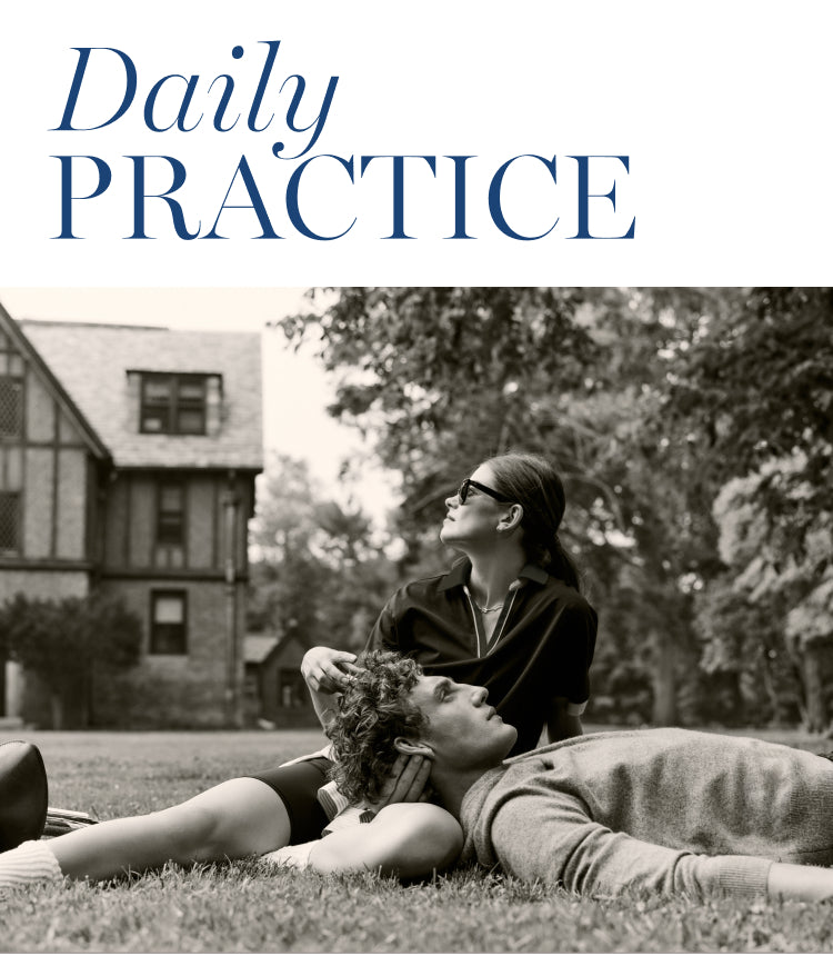 Black and white image of a man and woman sitting together in the grass. Copy says: Daily practice.