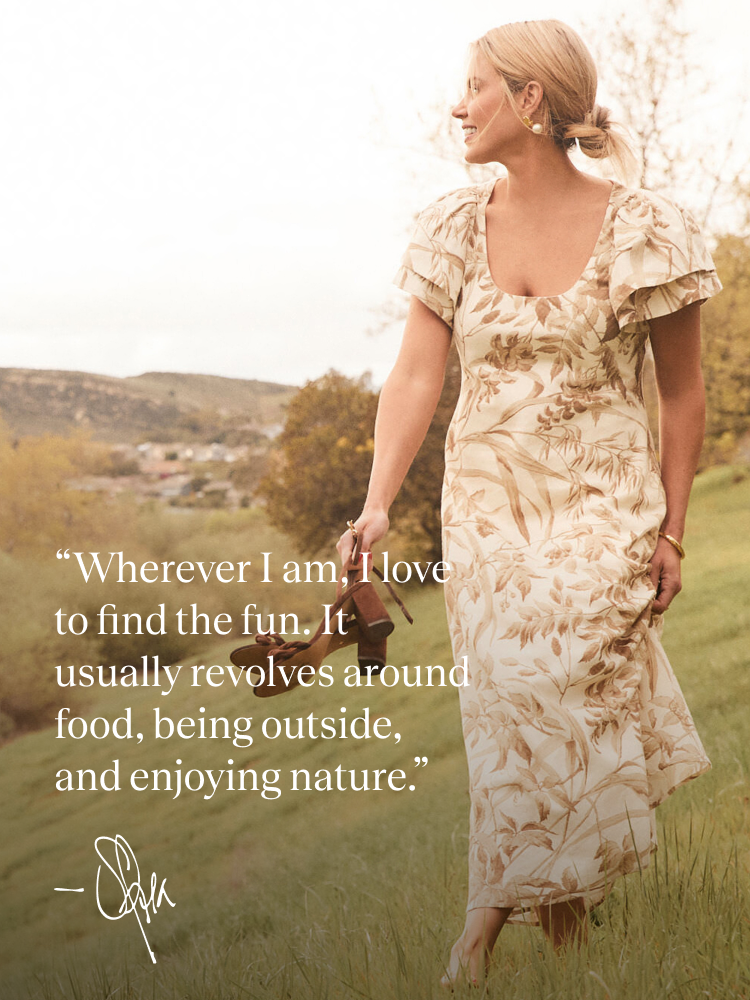 Shea McGee in a tropical patterned long dress with flutter sleeves.