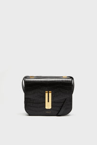 The Demellier black croc effect bag features a rectangular shape, gold-tone clasp, and adjustable crossbody strap, offering elegant style and meticulous detail.