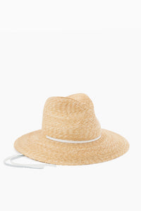 The Lola Hats wide-brimmed wheat straw hat features a classic white ribbon band and matching tie, blending timeless style with sun protection.
