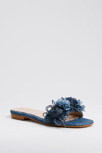 Tuckernuck Shoes Blue Textured Floral Embellished Slides feature an open toe, low heel, and floral strap accents—ideal for adding elegant charm to your summer style.