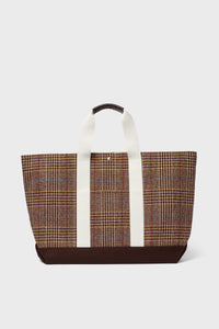 The Rue de Verneuil brown plaid wool tote features white handles and a dark brown base, making it a stylish weekender bag.
