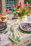 Rose Trellis Tablecloth elegantly drapes an outdoor dining table with tulips, vintage flatware, gingham napkins, creating a classic, effortless, high-end spring brunch setting.