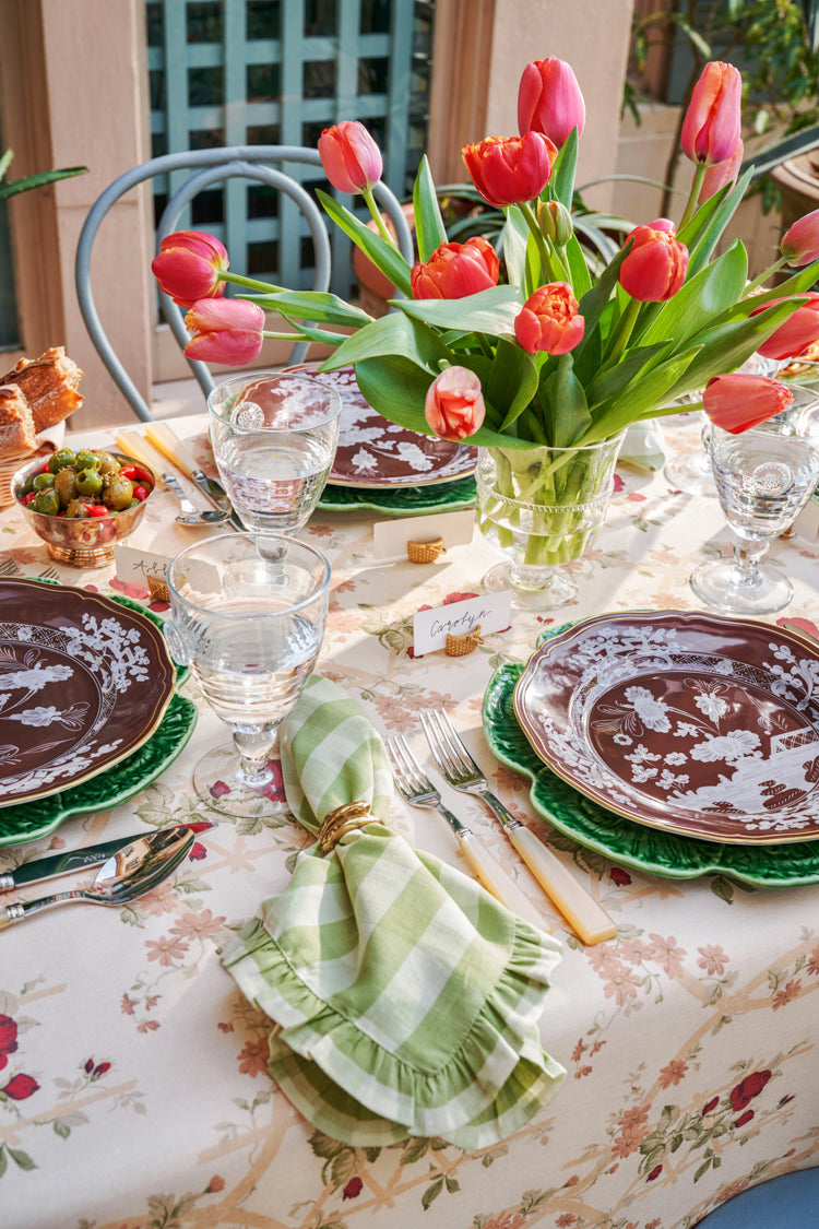 Berry and Thread Goblet adds classic elegance to a spring table setting with vibrant tulips, leaf-shaped chargers, and gingham napkins, embodying effortless, high-end dining.