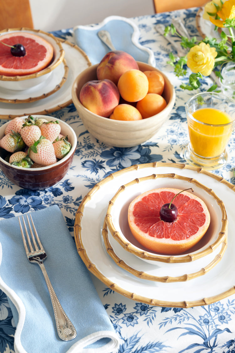 Classic Bamboo Dinner Plate with bamboo trim, part of an effortless, high-end breakfast setting featuring fruit bowls, a vibrant tablecloth, and sunny vibes for fun dining.
