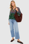 Model showcases the Chocolate Soft M Hobo, a classic and effortless oversized brown suede tote, paired with a bohemian blouse and jeans for a fun, high-end look.
