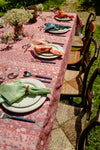 A summer table set with a red tablecloth and colorful napkins. 