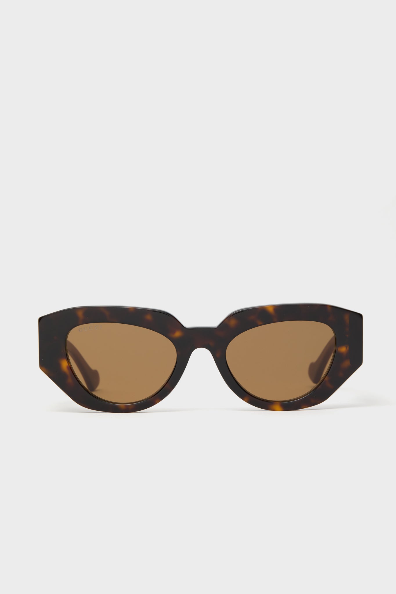 Gucci cat-eye sunglasses in brown tortoiseshell with dark lenses, shown from the front—a sophisticated luxury eyewear option.