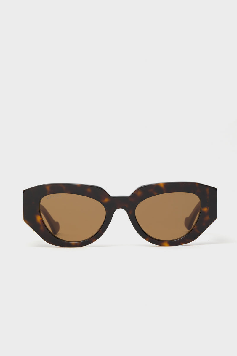 Gucci cat-eye sunglasses in brown tortoiseshell with dark lenses, shown from the front—a sophisticated luxury eyewear option.