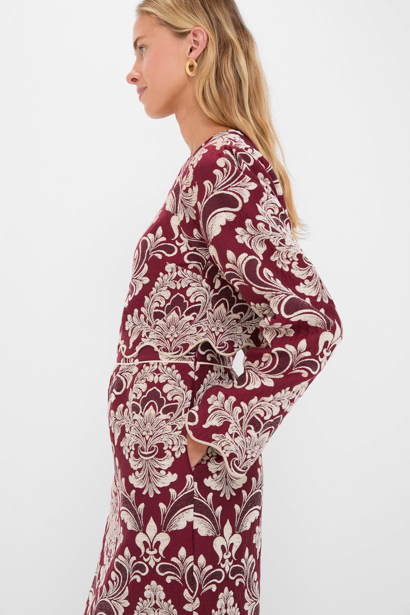 Blonde woman models the classic, high-end Blush Pink and Burgundy Bicolor Jacquard Waves Long Sleeve Top, effortlessly styled with a matching skirt and gold-tone hoop earring.