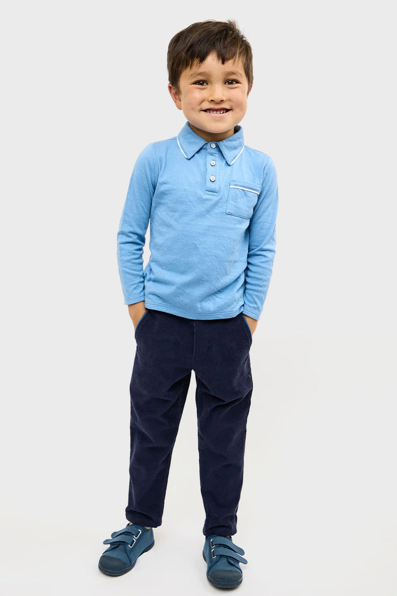 Young boy wearing the classic Blue Parker Polo with contrast piping and patch pocket, paired with navy pants and matching shoes, embodying an effortless, high-end style.
