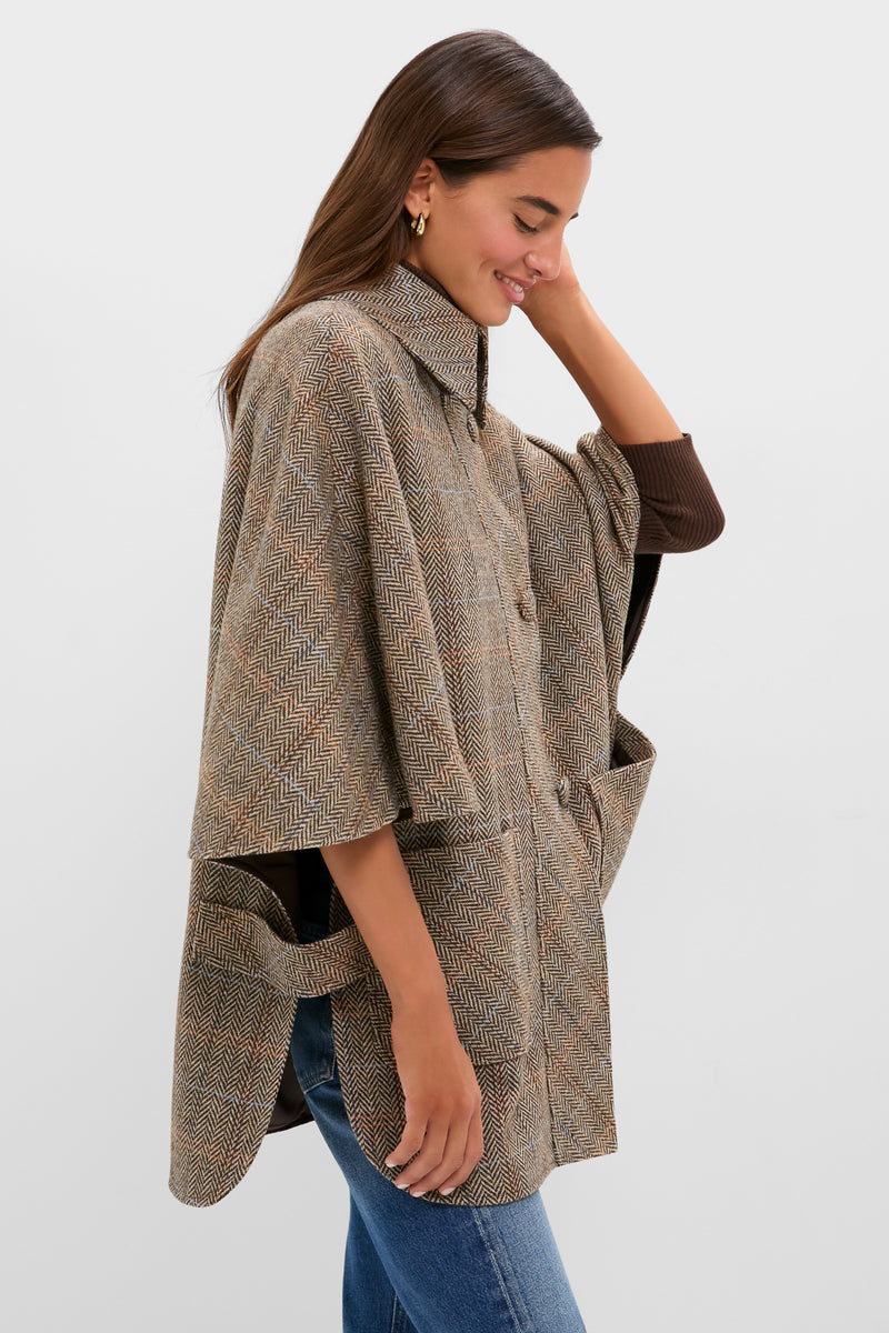Young woman in profile wearing the Herringbone Stewart Poncho with classic herringbone pattern, stand-up collar, and oversized pockets, creating an effortless, high-end look.