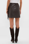 Person wearing Coffee Faux Faux Leather Fringe Paddock Mini Skirt with fringe detailing, paired with knee-high suede boots, embodying a classic, effortless, and fun high-end style.