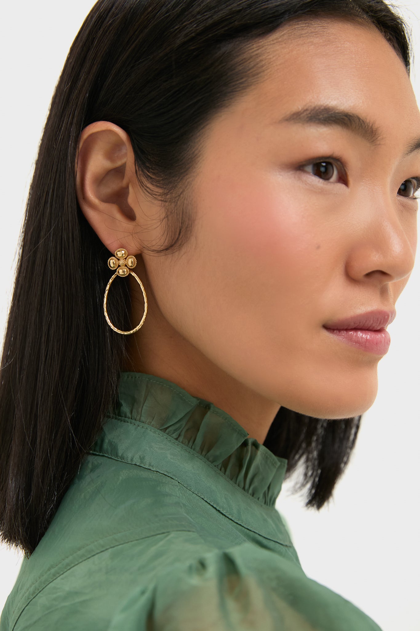 Berry Clover Teardrop Earrings - Gold worn by a woman, showcasing classic hammered gold teardrop hoops and mother of pearl clover studs for an effortless, high-end look.