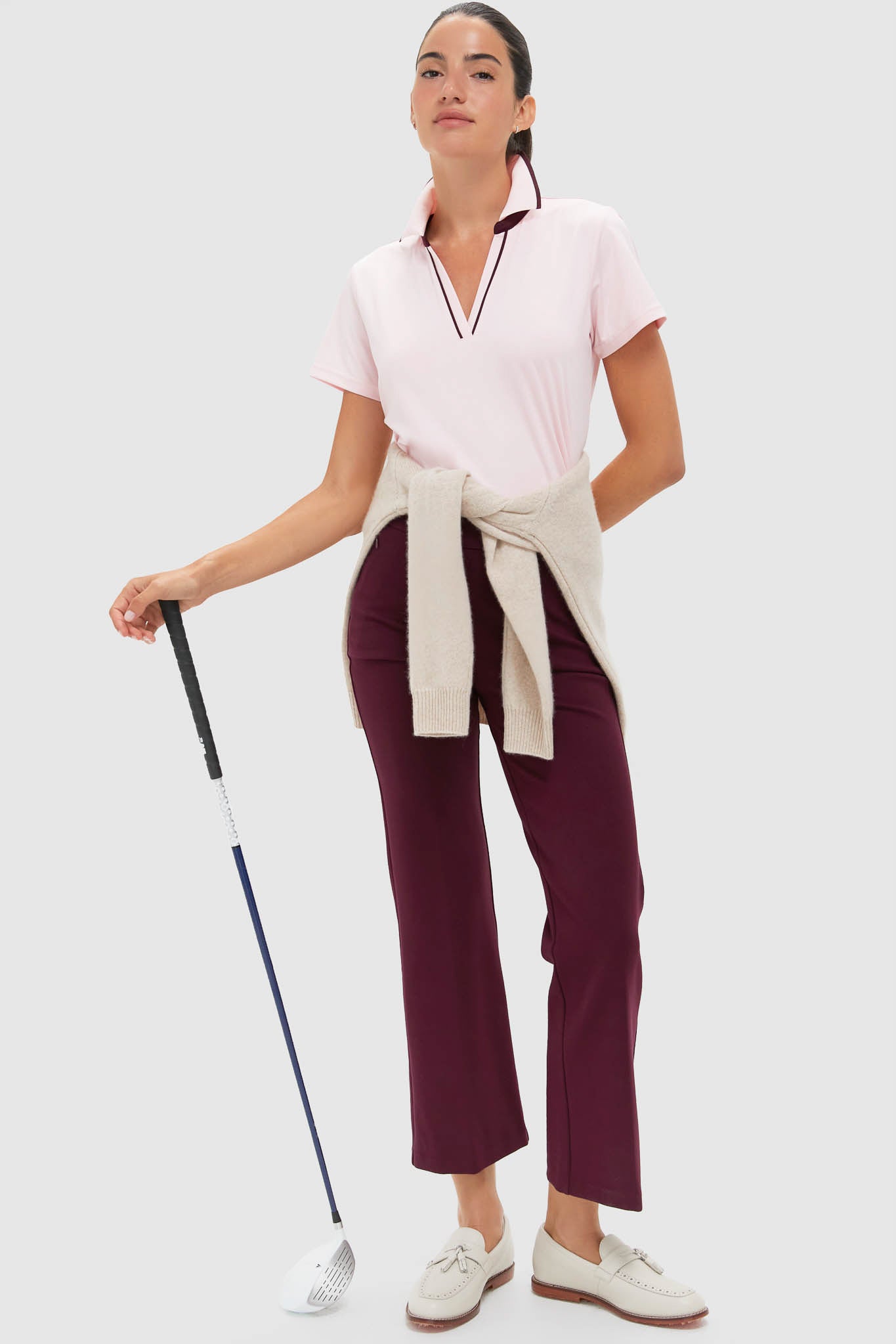 Model showcases the Pink Short Sleeve Performance Jersey Caroline Polo with a classic, effortless elegance, pairing fun, high-end style with practical golf-ready functionality.