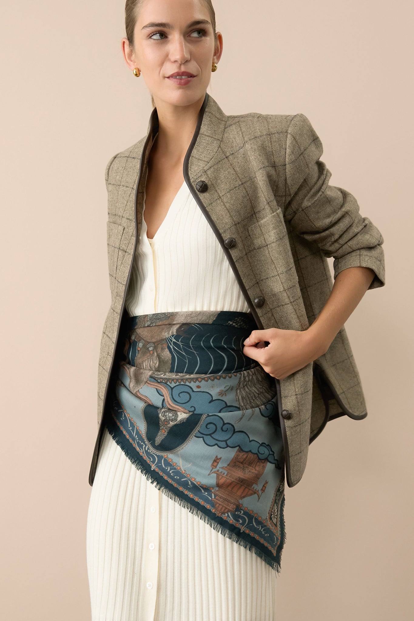Woman wearing the Brown Check Plaid Wool Dalton Jacket, effortlessly styled over a white rib-knit dress, exudes a classic, high-end look with fun, contrasting button details.