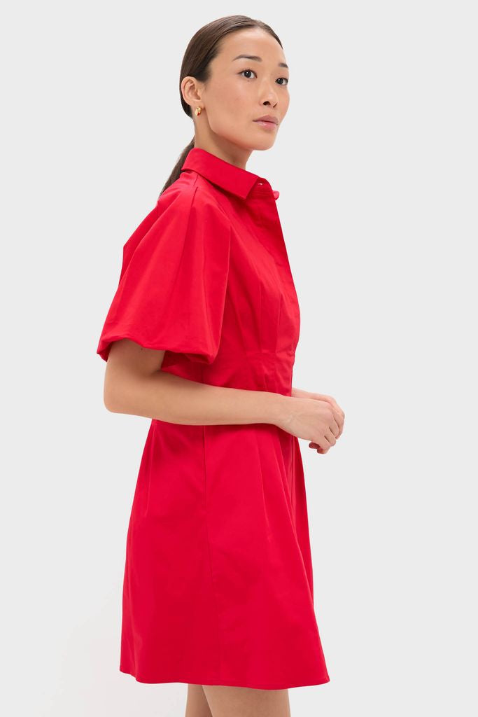 Woman in profile wearing the Red Mini Delaney Dress, showcasing classic, effortless style with a tailored spread collar and puff sleeves for a high-end, fun look.