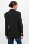 Back view of the Black Diana Blazer, showcasing classic gold button cuffs and an effortless oversized fit, paired with jeans for a high-end, fun look.