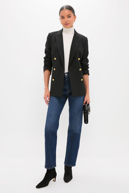 Woman wearing the Black Diana Blazer with gold buttons, exuding a classic and effortless style, paired with jeans and a turtleneck, embodying high-end, fun fashion.