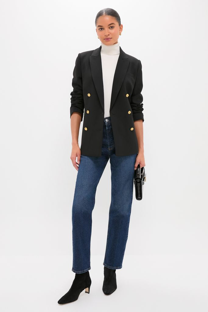 Woman wearing the Black Diana Blazer with gold buttons, exuding a classic and effortless style, paired with jeans and a turtleneck, embodying high-end, fun fashion.