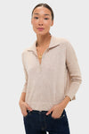 Woman in Tan Clayton Long Sleeve Knit Polo, a classic, effortless pullover with drop shoulders and spread collar, paired with dark jeans, embodying a high-end, fun style.