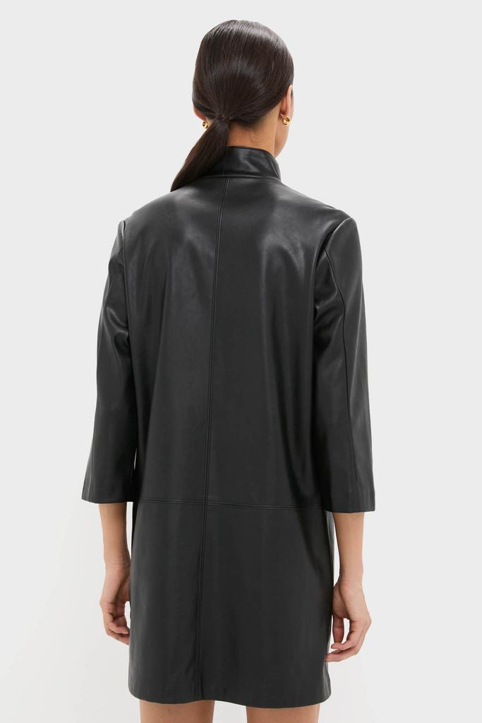 Woman in a black leather Clifton Dress with a stand collar and V-neck, embodying classic, effortless style. Perfect for fun, high-end occasions.