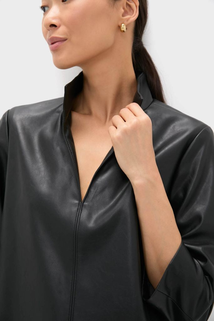Woman wearing the Black Leather Clifton Dress with a stand collar and V-neckline, showcasing its classic and effortless style, paired with simple gold hoop earrings.