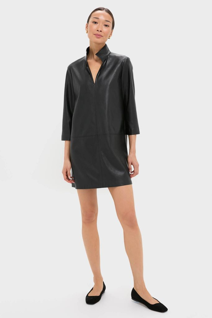 Woman models the Black Leather Clifton Dress, a classic, effortless mini with stand collar and three-quarter sleeves, paired with ballet flats for a fun, high-end look.