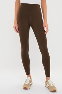 Classic Chocolate Brown High Rise Compression Spandex MacKenzie Legging, offering an effortless, high-end look with a flattering fit, styled with tan sneakers in a fun, studio setting.