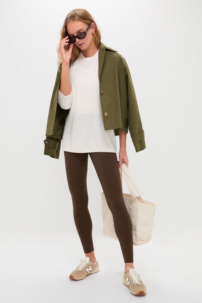 Woman in a classic, effortless outfit featuring Chocolate Brown High Rise Compression Spandex MacKenzie Leggings, styled with a knit sweater, olive jacket, and beige sneakers.