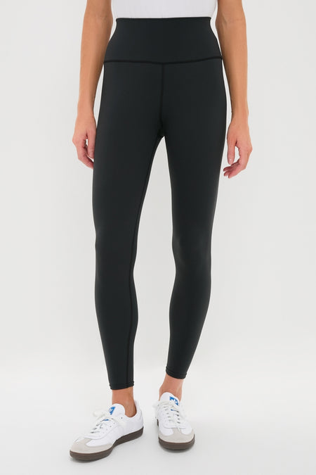 Classic Black High Rise Compression Spandex MacKenzie Legging paired with white sneakers, showcasing an effortless and flattering fit, perfect for fun, high-end activities.