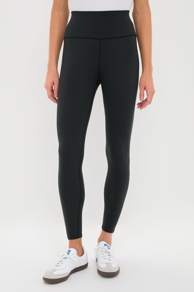 Classic Black High Rise Compression Spandex MacKenzie Legging paired with white sneakers, showcasing an effortless and flattering fit, perfect for fun, high-end activities.