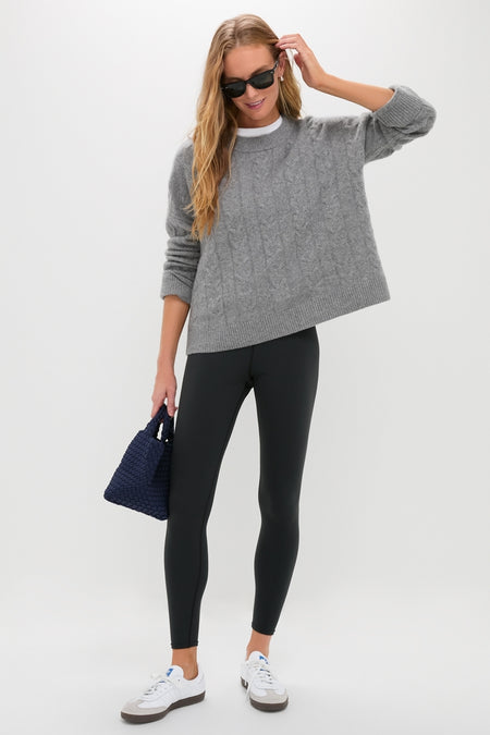 Woman wearing classic Black High Rise Compression Spandex MacKenzie Legging, exuding effortless style with a fun, relaxed pose, pairing high-end accessories and casual attire.