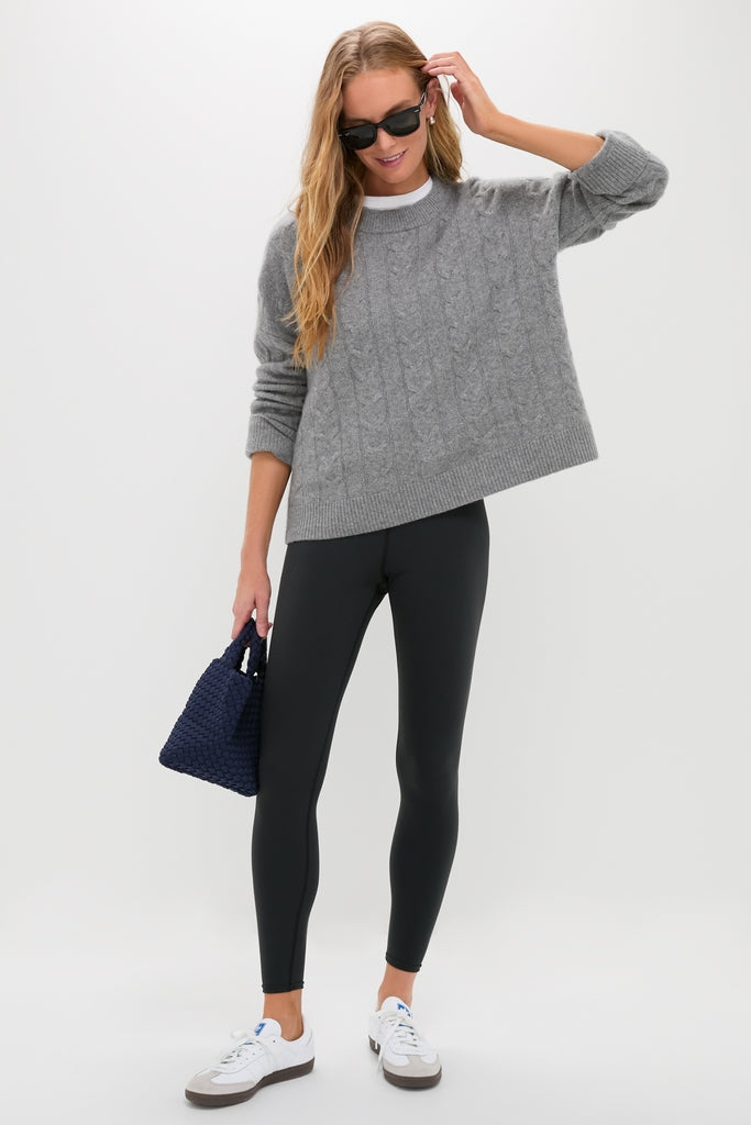 Woman wearing classic Black High Rise Compression Spandex MacKenzie Legging, exuding effortless style with a fun, relaxed pose, pairing high-end accessories and casual attire.