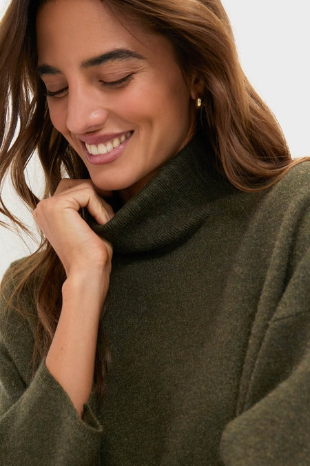 Young woman wearing the classic Moss Green Vivianne Dress, an effortless, high-end turtleneck sweater with a cozy, fun vibe, perfectly embodying Tuckernuck's style.