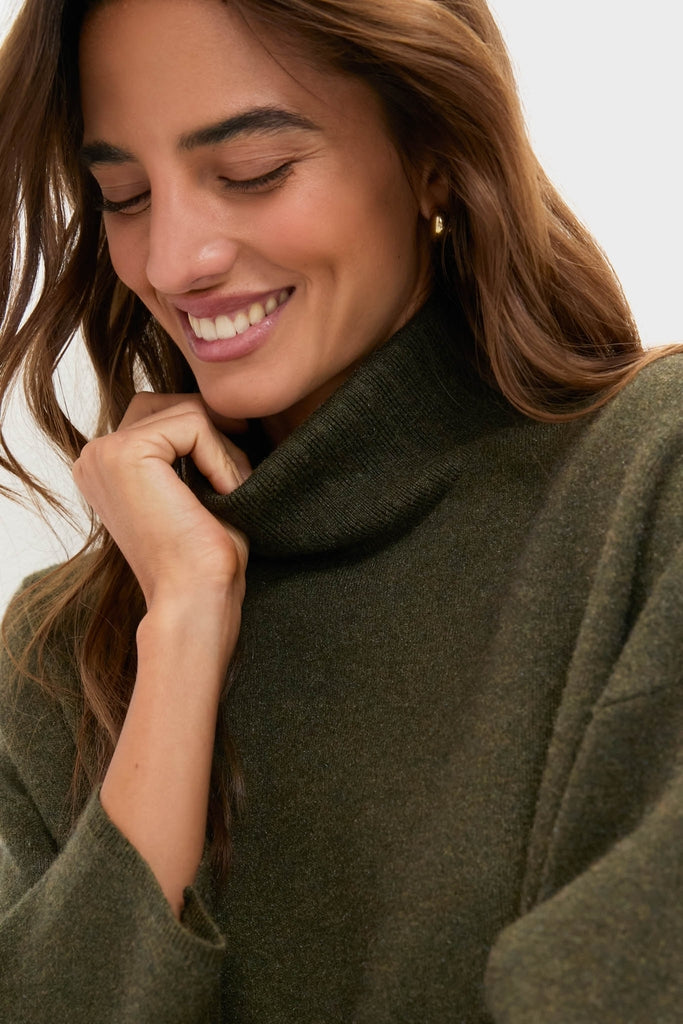 Young woman wearing the classic Moss Green Vivianne Dress, an effortless, high-end turtleneck sweater with a cozy, fun vibe, perfectly embodying Tuckernuck's style.