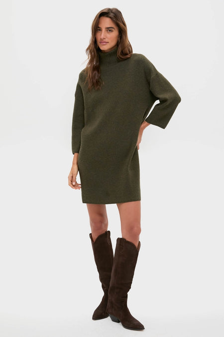 Woman modeling the classic Moss Green Vivianne Dress, an effortless long-sleeve sweater dress with a mock turtleneck, paired with high-end brown knee-high boots.