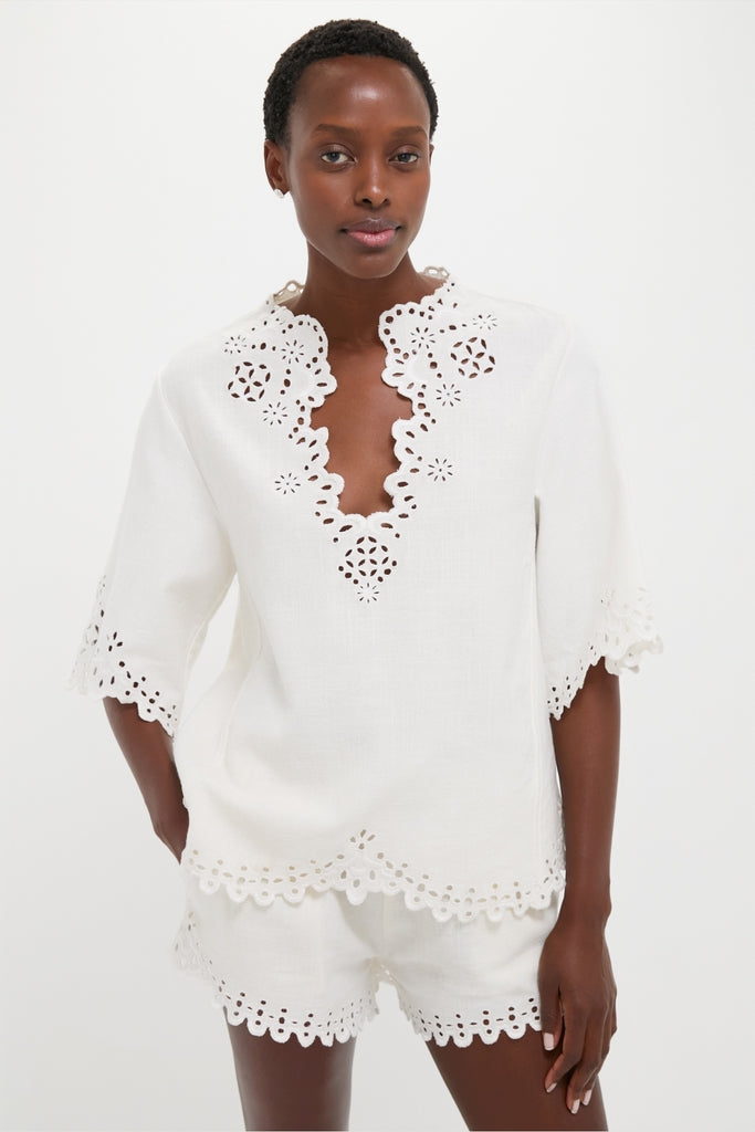 Model wearing the classic White Shana Blouse, featuring effortless openwork embroidery and a relaxed fit, paired with matching shorts for a fun, high-end summer look.