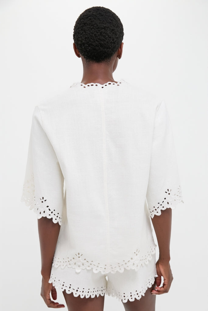 Model in classic, effortless White Shana Blouse with scalloped embroidery, showcasing fun, high-end style. Perfect for versatile, confident looks.