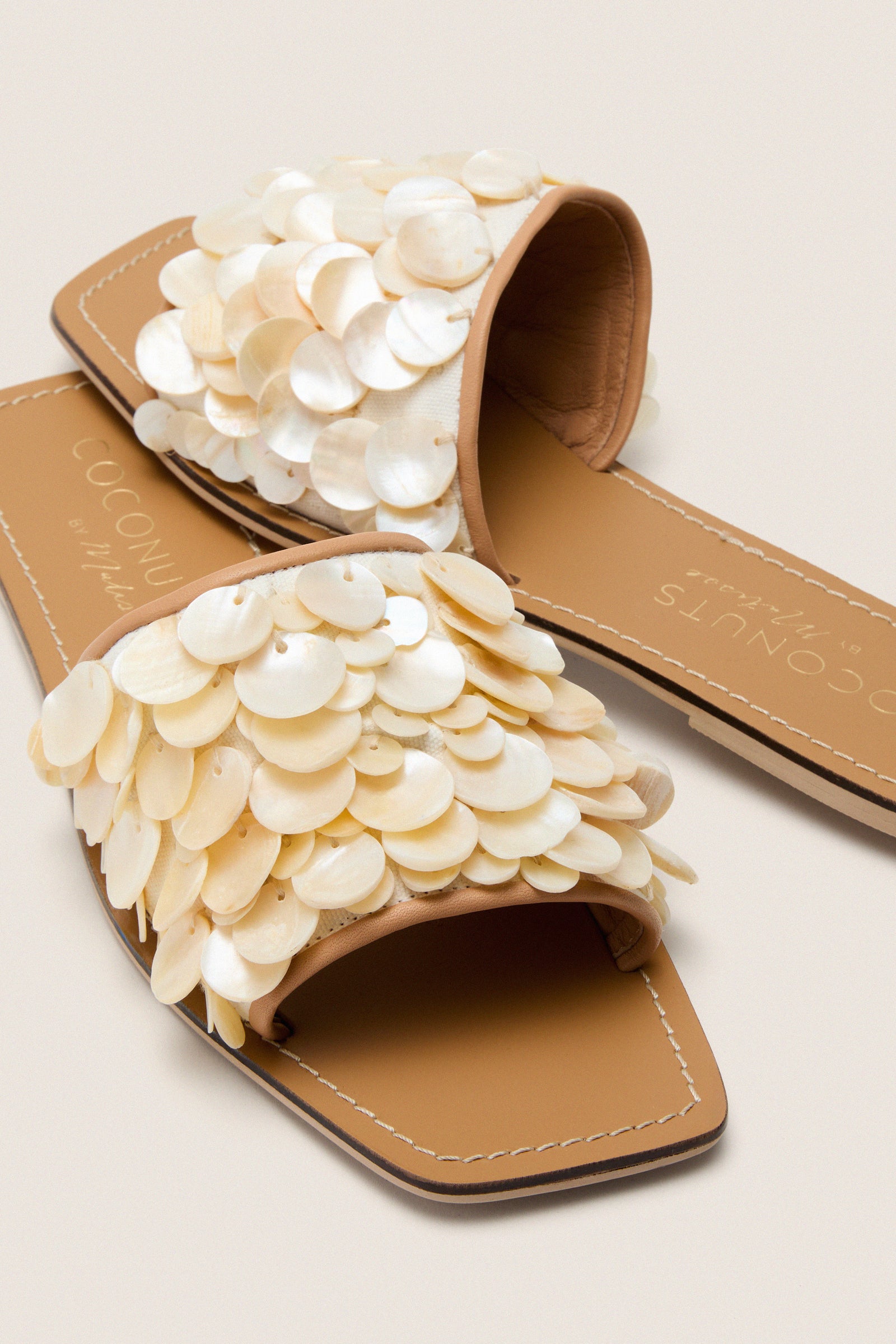 Natural Waverly Sandals feature classic, shell-embellished white straps and a flat sole, offering an effortless, high-end look perfect for fun, breezy summer outings.