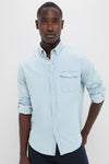 Man wearing a classic Light Blue Washed Denim Shirt with rolled sleeves and a chest pocket, evoking an effortless, high-end, and fun Americana style.