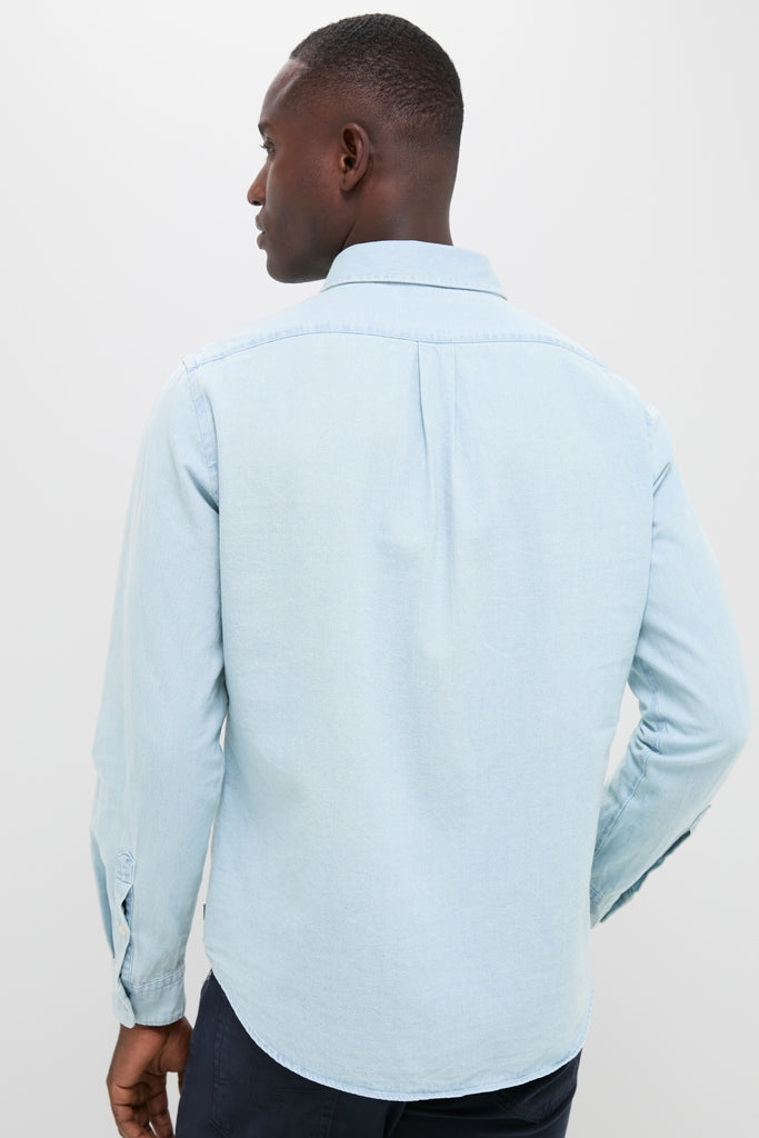 Back view of a man in a classic Light Blue Washed Denim Shirt, showcasing effortless style with a fun, high-end touch. Perfect for year-round versatility.